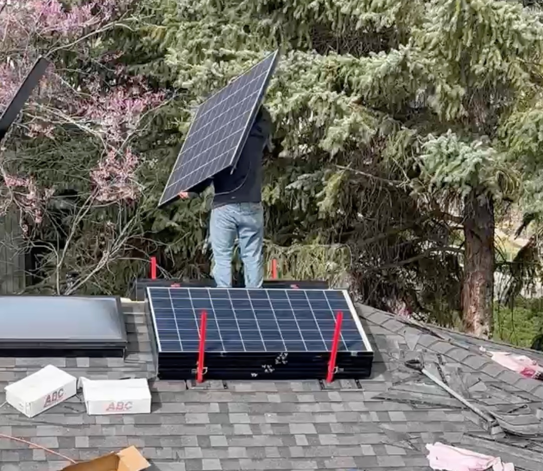 Roofer carrying a solar panel to RoofRak on a roof